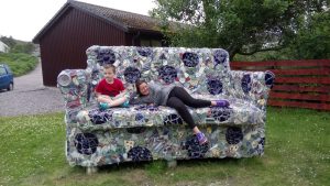 Two people on a huge sofa outdoors