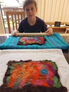 Photo of a child rolling the felt artwork on a towel