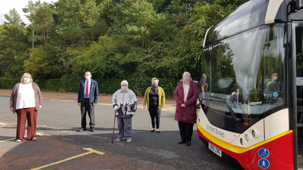 Community members in front of a bus