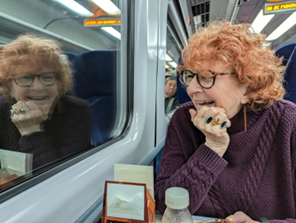 Jane on the train to Edinburgh, smiling and laughing